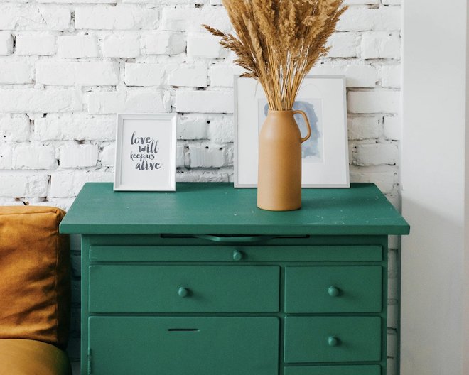 green drawers against white brick wall